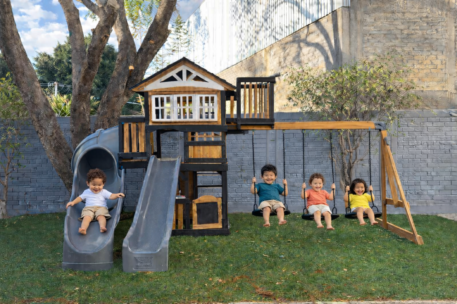 Niños jugando en el jardín: resbaladillas y columpios en la zona infantil al aire libre de Diversitopia.